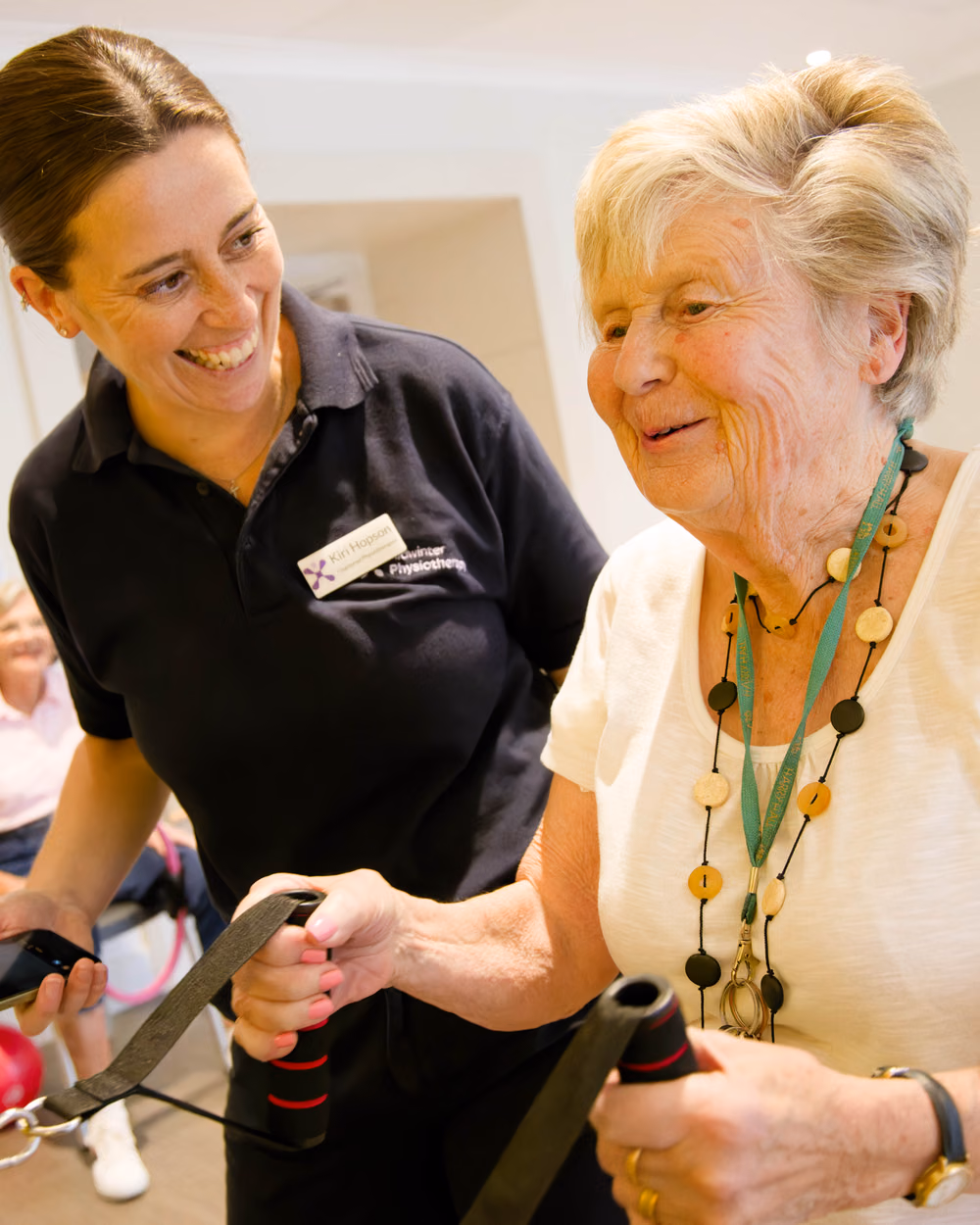 A physiotherapist supporting a client through hands-on strength and rehabilitation exercises